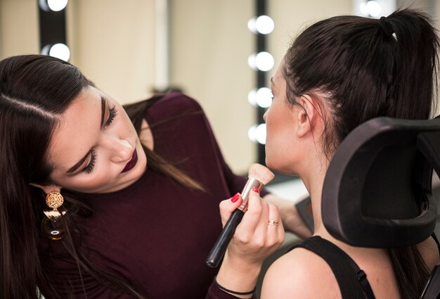 Artista aplicando maquillaje en modelo