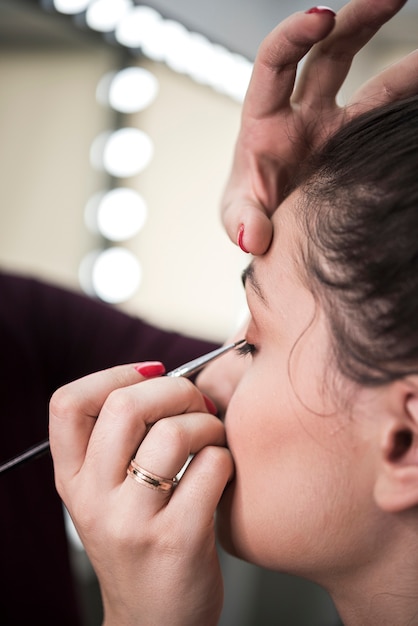 Artista aplicando sombra de ojos con pincel