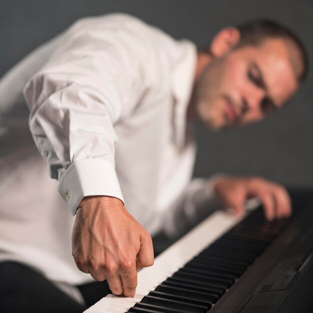 Artista borrosa tocando varias octavas en piano digital