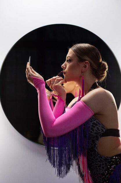 Artista de cabaret femenino preparándose con maquillaje entre bastidores