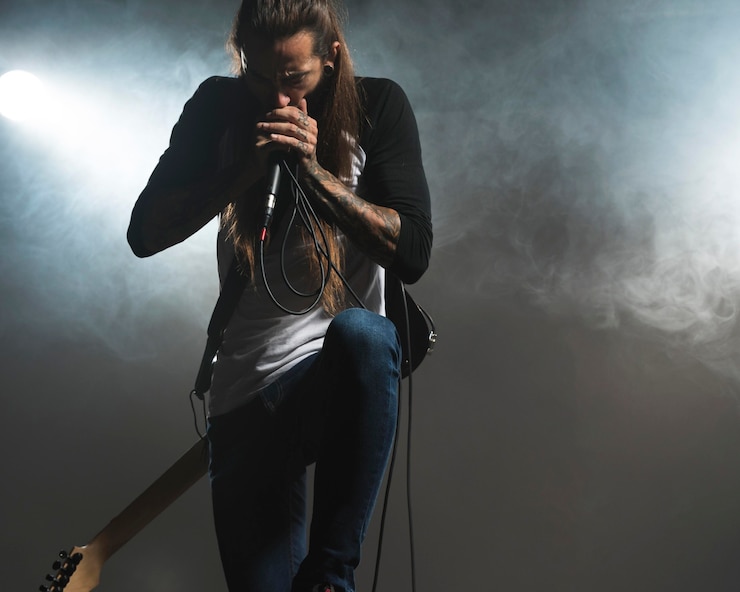 Foto gratuito artista cantando en el escenario efecto humo.