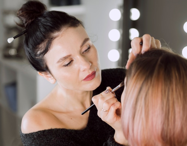 Artista enfocado haciendo maquillaje