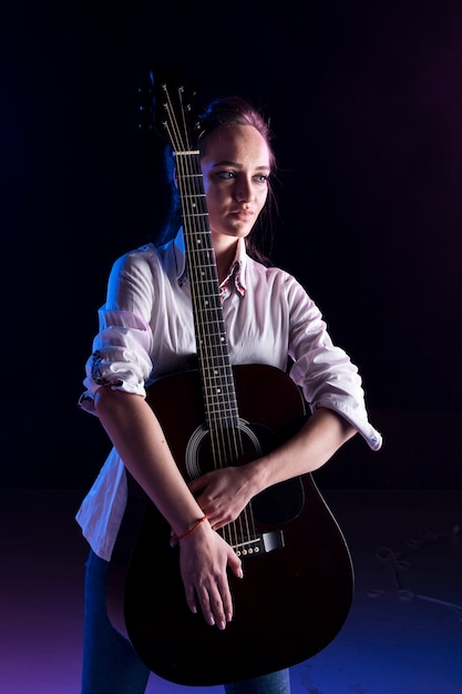 Foto gratuita artista en el escenario abrazando la guitarra