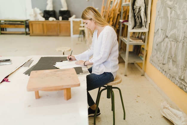 Artista femenina dibujar sobre papel en el taller