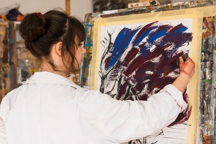 Foto gratuito artista femenina profesional pintando sobre lienzo con pincel.