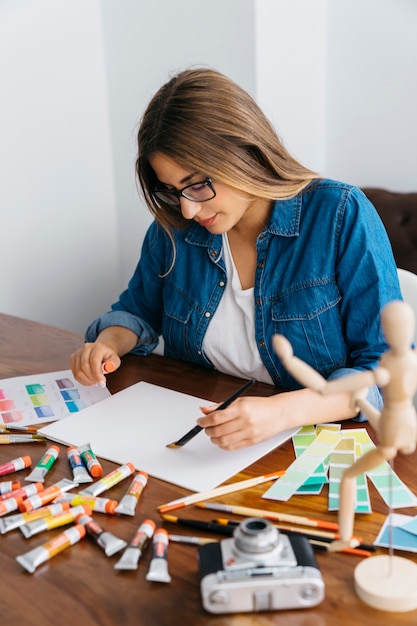 Foto gratuita artista femenina trabajando en escritorio