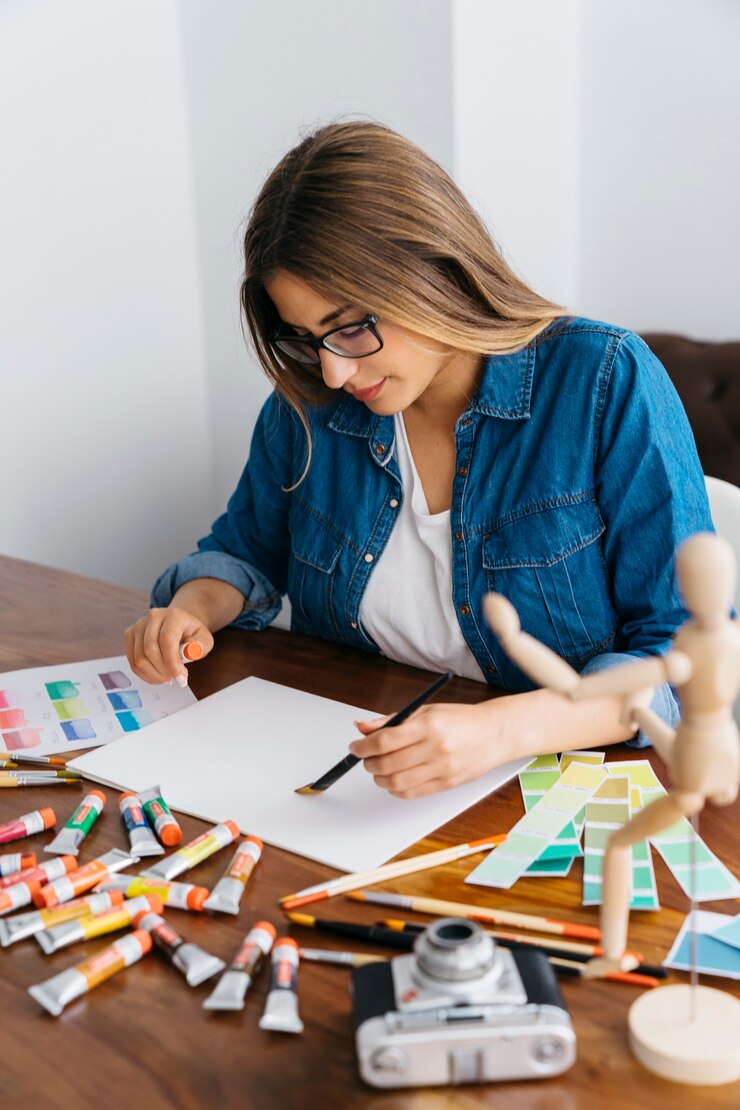 Foto gratuito artista femenina trabajando en escritorio