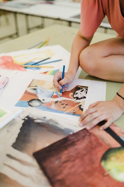 Artista femenino para colorear con lápiz azul sobre papel de lienzo