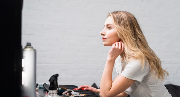 Artista de maquillaje sentado en el tocador