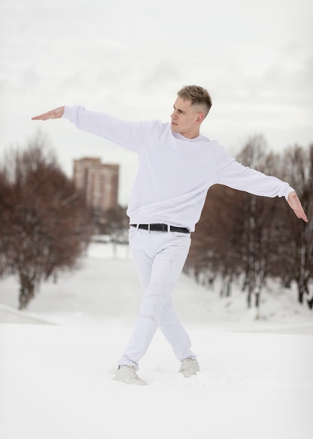 Artista masculino de hip hop posando afuera con nieve