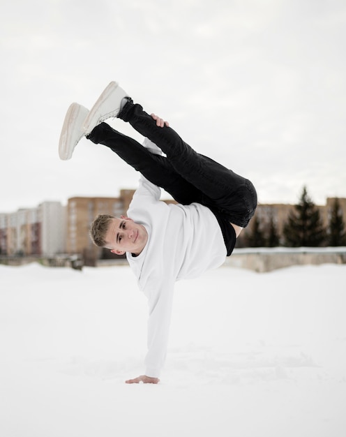 Foto gratuita artista masculino de hip hop posando mientras baila fuera