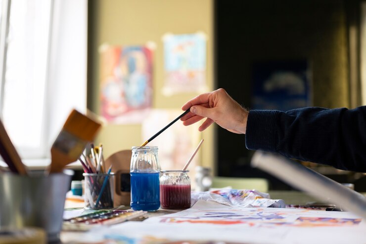 Foto gratuito artista masculino pintando con acuarela en el estudio.