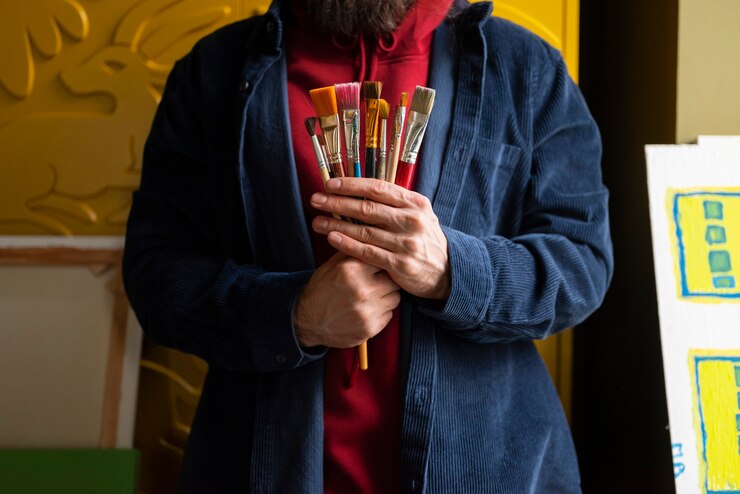Foto gratuito artista masculino pintando con acuarela en el estudio.