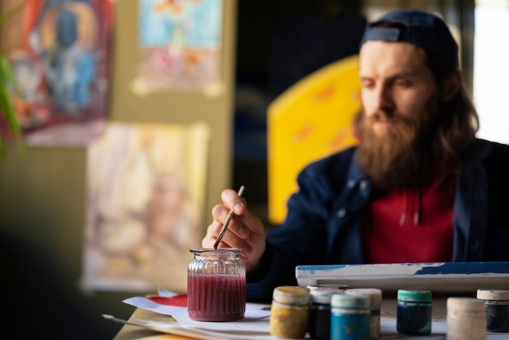 Foto gratuito artista masculino pintando con acuarela en el estudio.
