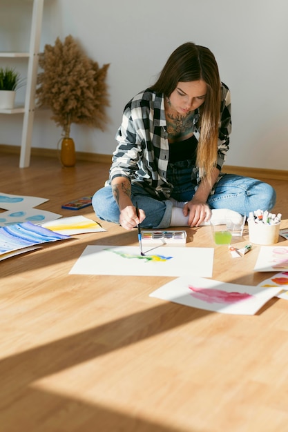 Artista mujer pintando en el suelo