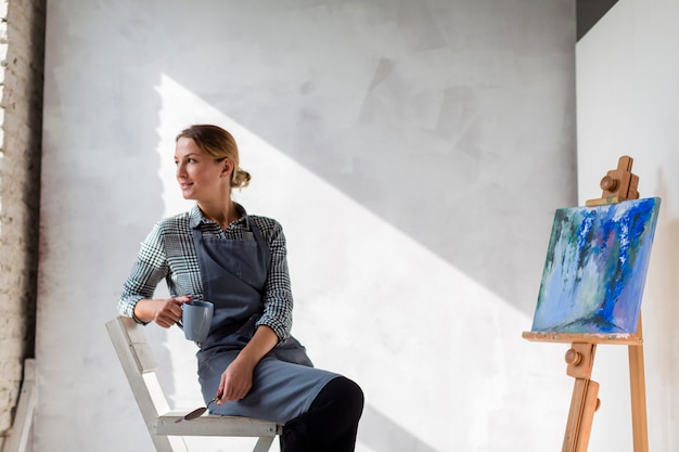 Artista mujer posando en silla con lona