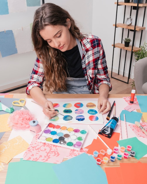 Artista de la mujer que pinta el círculo abstracto en el Libro Blanco