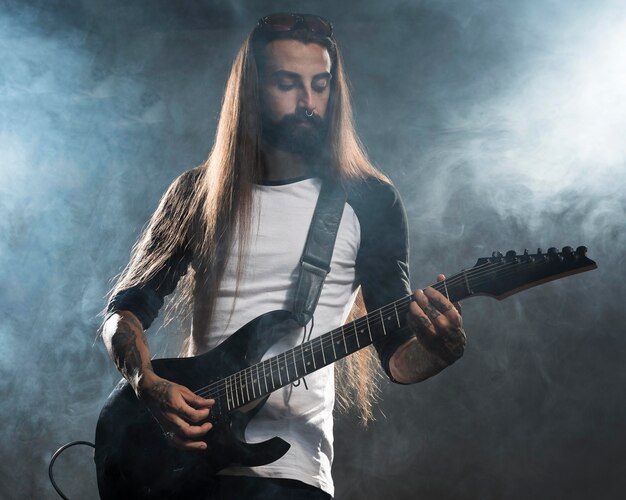 Artista con pelo largo tocando la guitarra