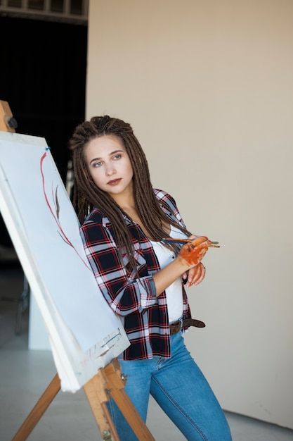 Artista pintando en lienzo en estudio