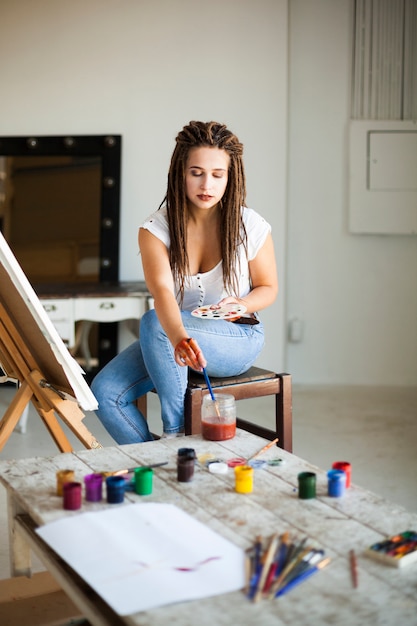 Artista pintando en lienzo en estudio