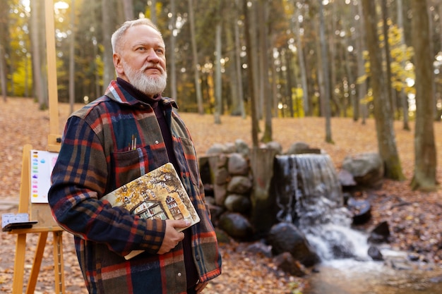 Foto gratuita artista de pintura de acuarela al aire libre en el bosque