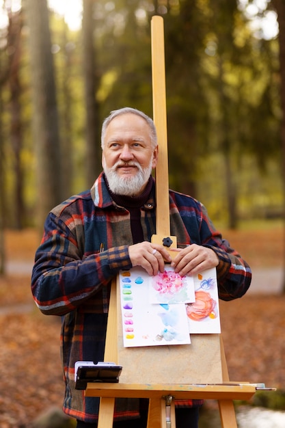 Foto gratuita artista de pintura de acuarela al aire libre en el bosque