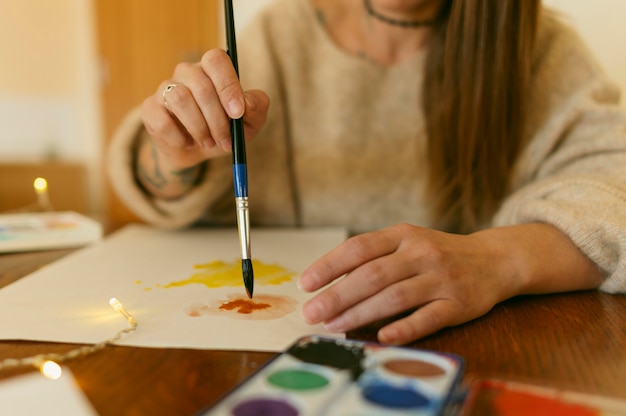 Artista de primer plano con un pincel sobre papel