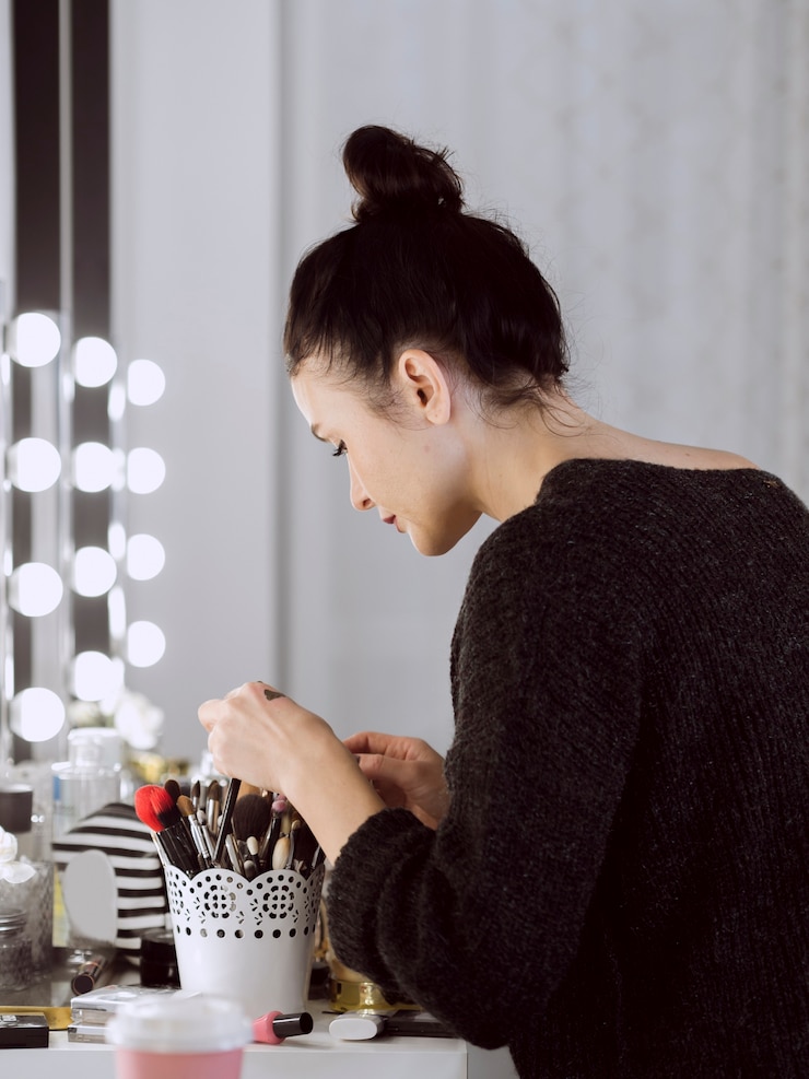 Foto gratuito artista profesional mirando pinceles de maquillaje