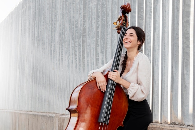 Artista sonriente de plano medio con instrumento