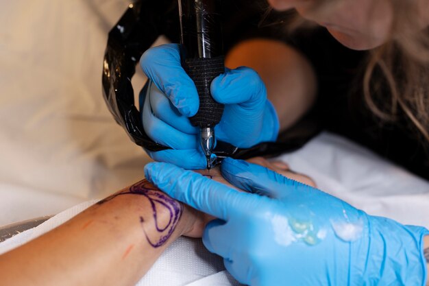 Artista del tatuaje con guantes de alto ángulo