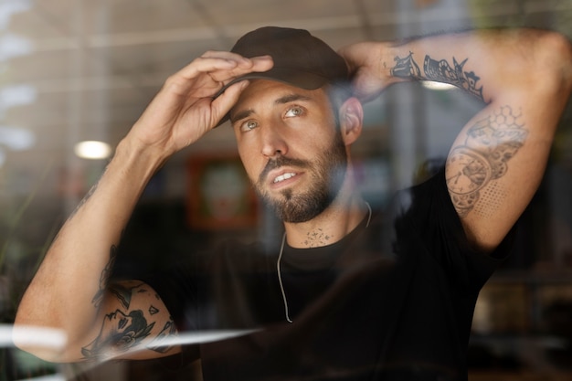 Artista del tatuaje de vista frontal con gorra