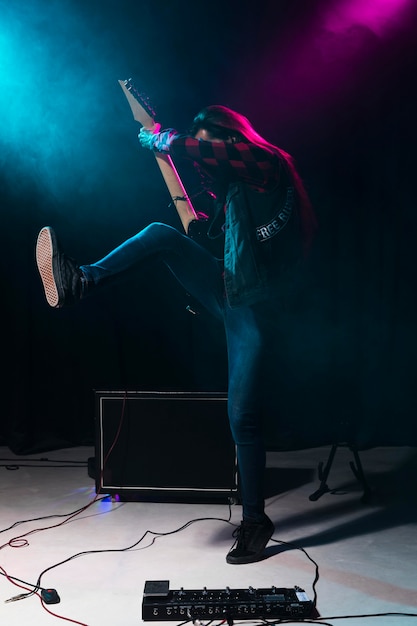 Artista tocando la guitarra y saltando