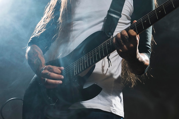 Artista tocando guitarra tiro medio