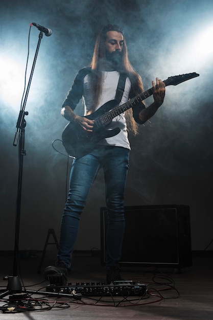 Foto gratuita artista tocando la guitarra vista larga