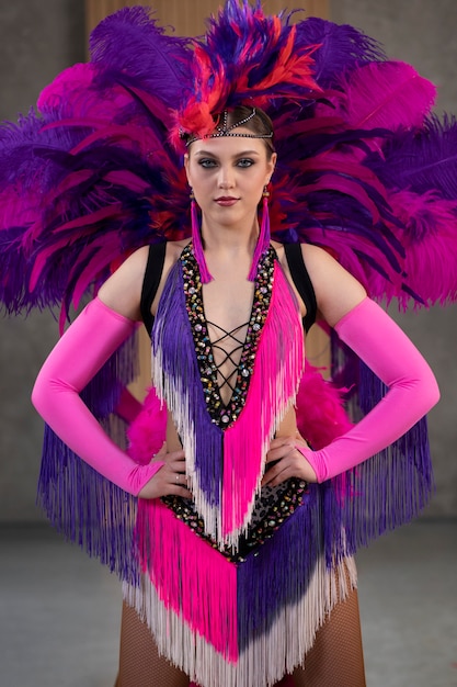 Artistas femeninas de cabaret posando entre bastidores con trajes de plumas