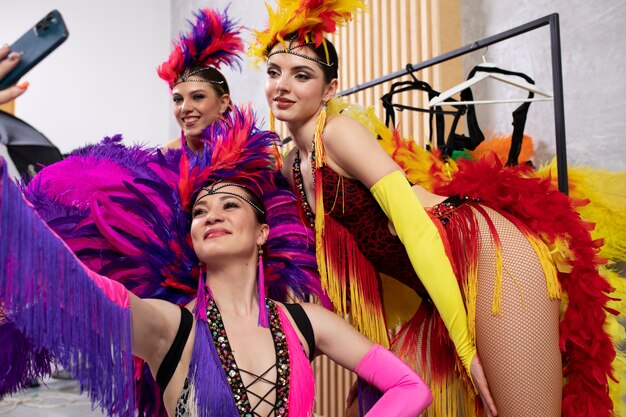 Artistas femeninas de cabaret tomándose un selfie juntas entre bastidores con disfraces
