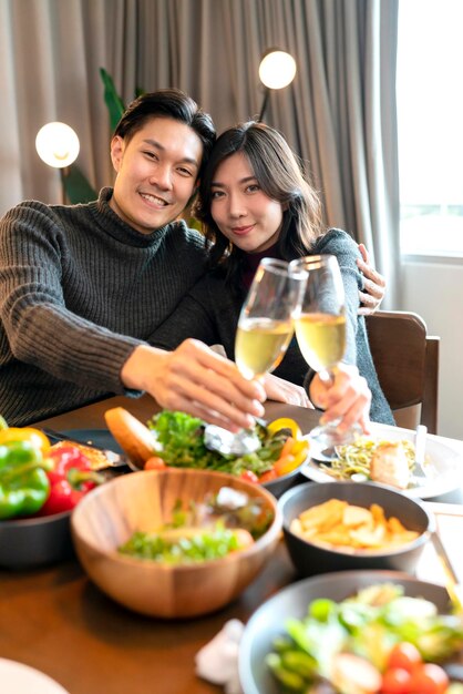 Asia casarse pareja felicidad alegre cena Hermosa pareja adulta brindando con copas de vino sentado en la mesa de madera cena de acción de gracias navidad festiva familia celebrar concepto