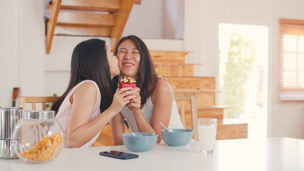 Asiático lesbianas lgbtq mujeres pareja dando presente hogar