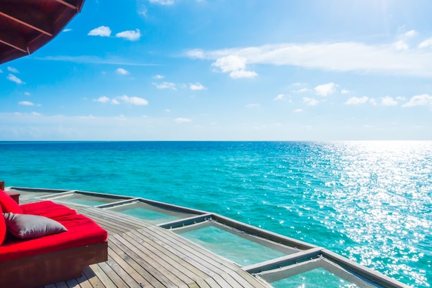 Asiento de red de vacaciones en la isla tropical de Maldivas y la belleza del mar con los arrecifes de coral