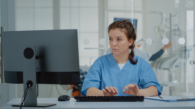 Asistente de estomatología escribiendo en el teclado de la computadora