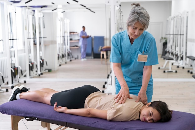 Asistente médico ayudando al paciente con ejercicios de fisioterapia