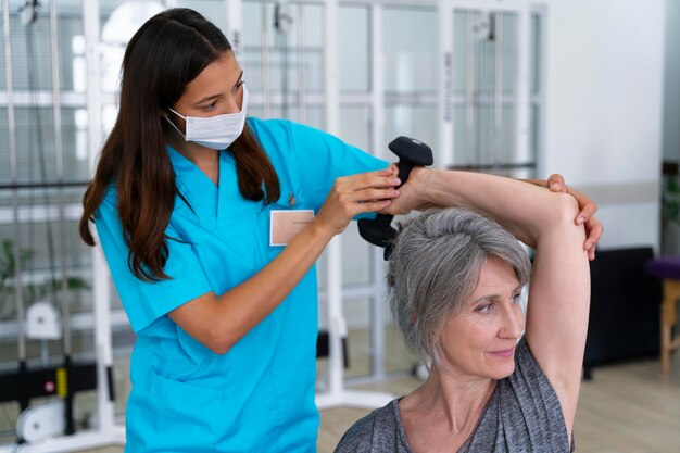 Asistente médico ayudando al paciente con ejercicios de fisioterapia