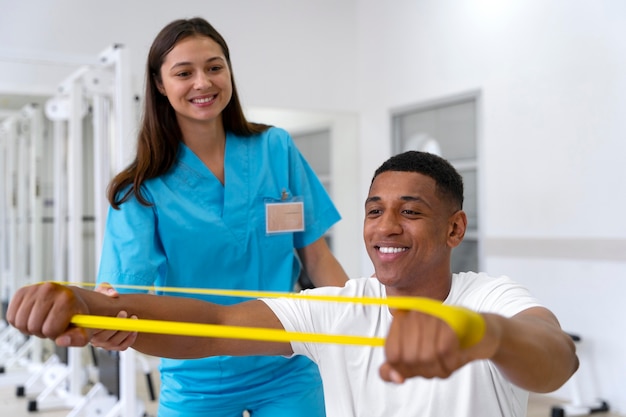 Foto gratuita asistente médico ayudando al paciente con ejercicios de fisioterapia