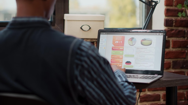 Foto gratuito asistente de ventas que planifica gráficos comerciales en portátiles digitales, trabaja con comercio electrónico y gestión de compras electrónicas en la oficina de la empresa. gerente usando estadísticas para desarrollar proyectos creativos.
