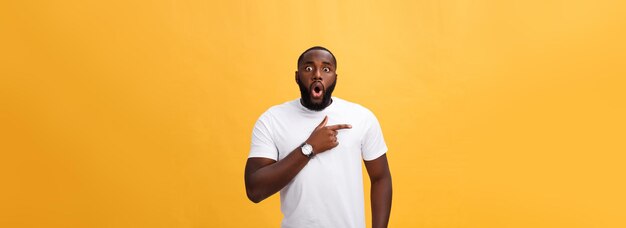 Asombrado joven hipster afroamericano con camiseta blanca tomados de la mano en gesto sorprendido manteniendo