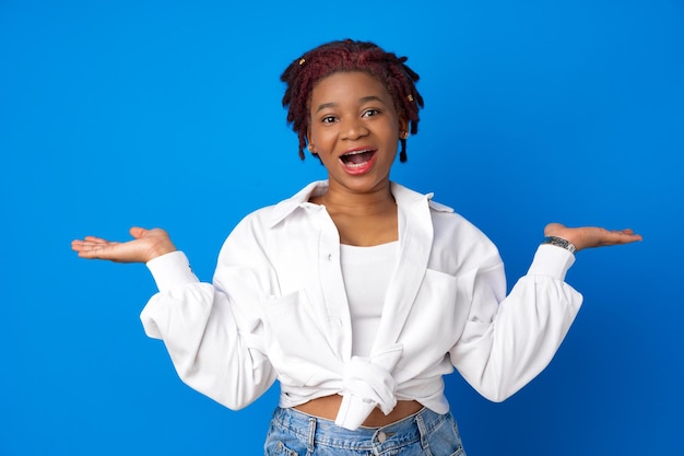 Asombrado sorprendido mujer afroamericana contra el fondo azul del estudio