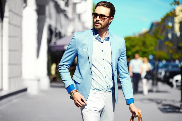 Aspecto de alta moda Joven elegante y confiado feliz apuesto hombre de negocios modelo en traje de estilo de vida en la calle en gafas de sol