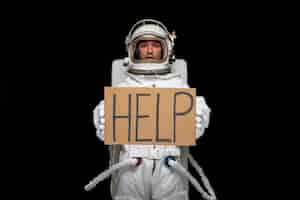 Foto gratuita astronauta día astronauta en cosmos traje espacial casco con cartel de ayuda escrito en armario asustado