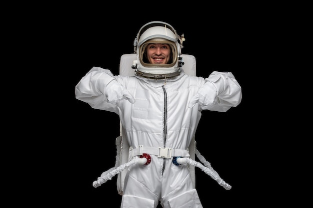 Astronauta día astronauta en el espacio ultraterrestre cosmos traje espacial casco sonriendo apuntando hacia abajo