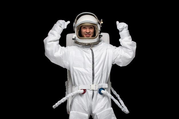 Astronauta día astronauta en galaxia emocionado aterrizó traje espacial vidrio casco puños arriba feliz